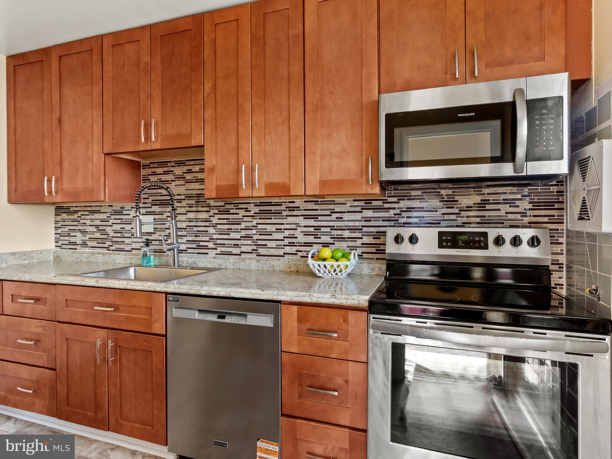 3405 Fredale Street Silver Spring, MD 20906 - Photo 9 of 34 a kitchen with stainless steel appliances a stove microwave and sink