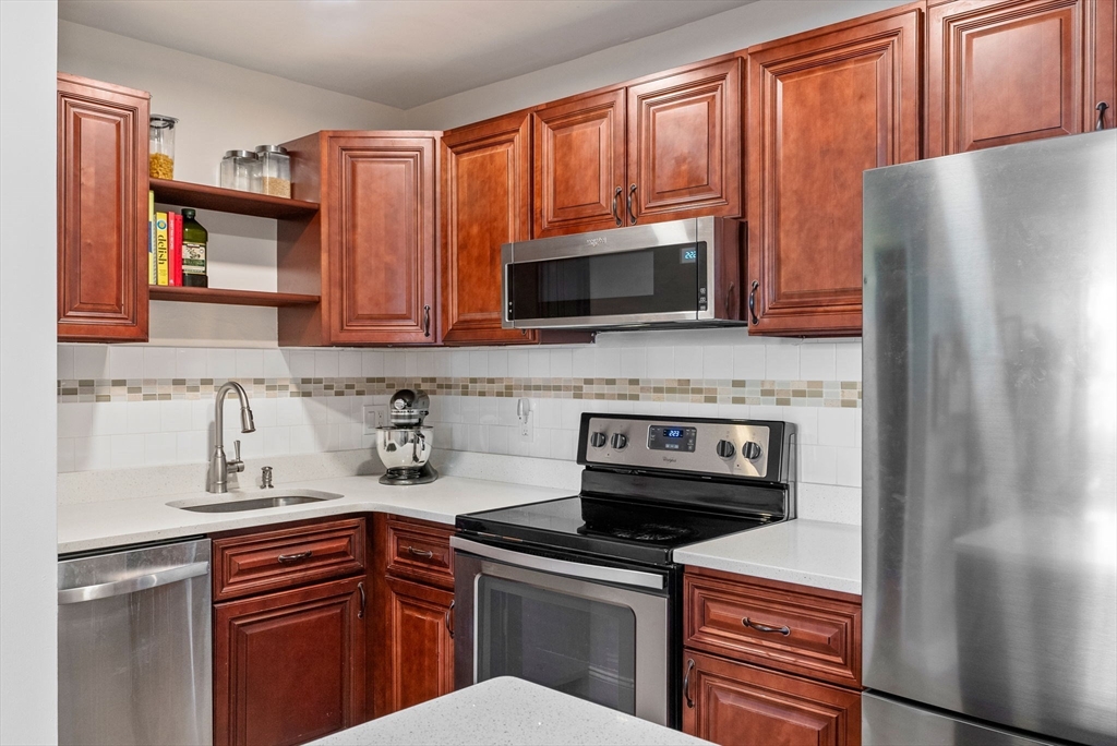 69 East Berkeley Street, Unit 5 Boston, MA 02118 - Photo 11 of 27 a kitchen with granite countertop a refrigerator stove and microwave