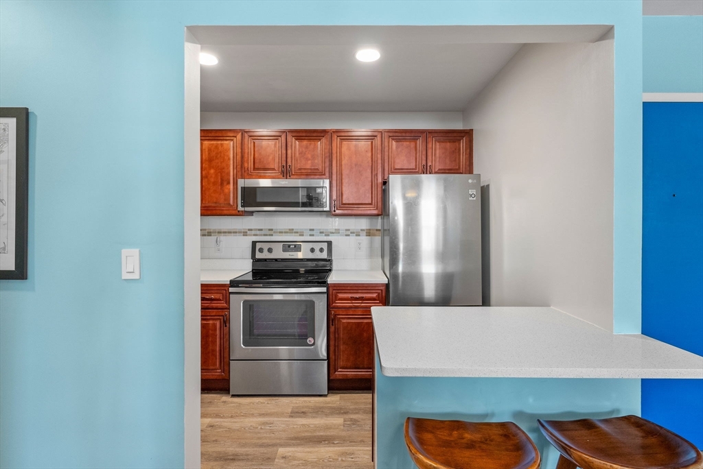 69 East Berkeley Street, Unit 5 Boston, MA 02118 - Photo 9 of 27 a kitchen with stainless steel appliances granite countertop a stove a refrigerator and a microwave