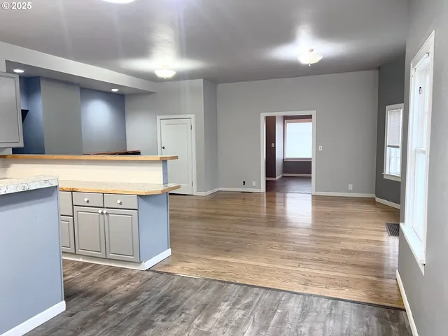 a view of a kitchen with kitchen island a sink wooden floor and a refrigerator