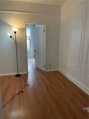 an empty room with wooden floor and mirror
