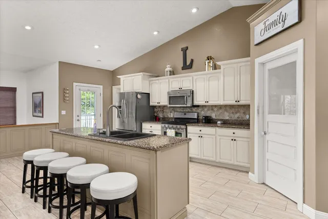 a kitchen with stainless steel appliances kitchen island granite countertop a sink and cabinets