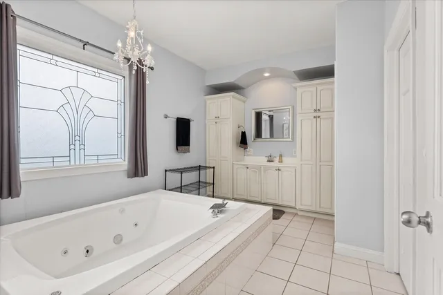 a bathroom with a tub a sink and a mirror