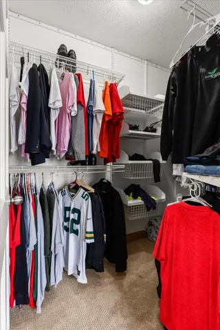 a view of walk in closet with clothes and shoes
