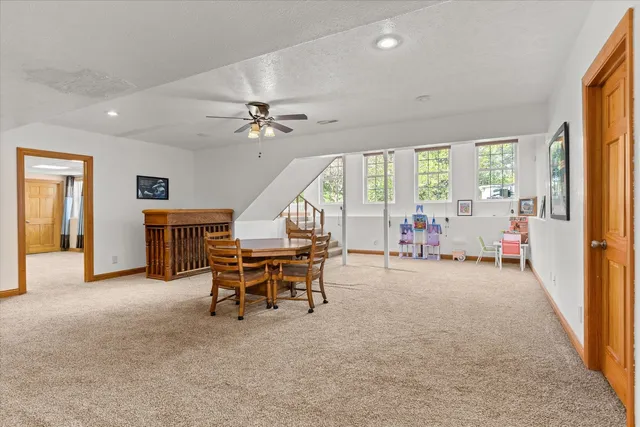 a view of a livingroom with furniture a ceiling fan and windows