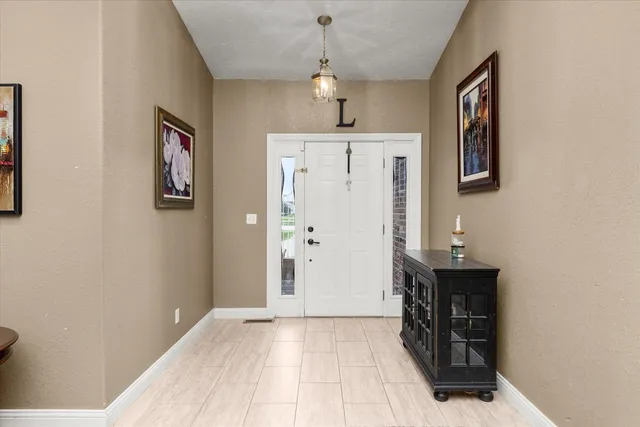 a view of a hallway with entryway dining room and wooden floor