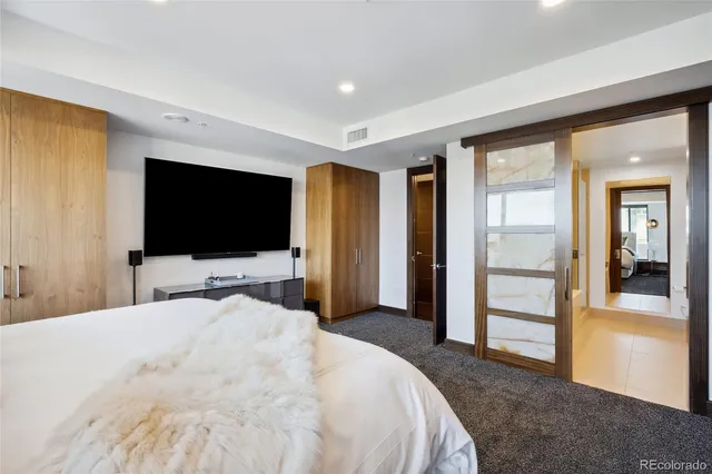 a bedroom with a bed and a flat screen tv