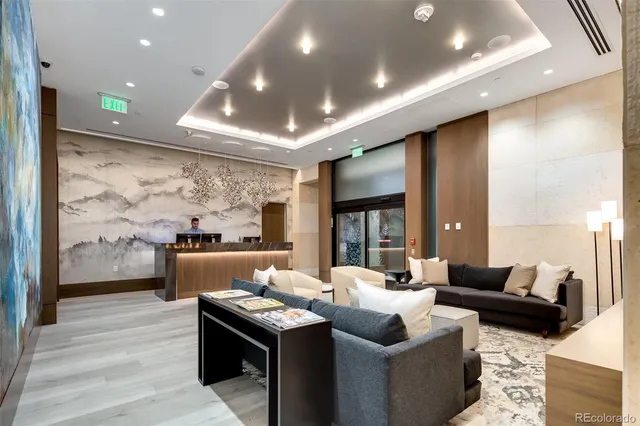 a living room with furniture a floor to ceiling window and wooden floor