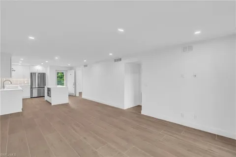 a view of a big room with wooden floor and windows