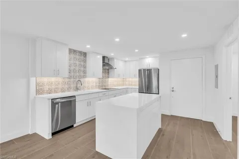 a kitchen with stainless steel appliances granite countertop a sink and a refrigerator