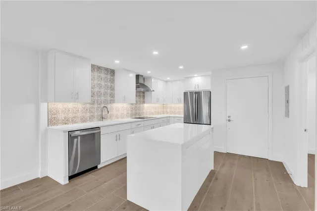 a kitchen with stainless steel appliances granite countertop a sink and a refrigerator