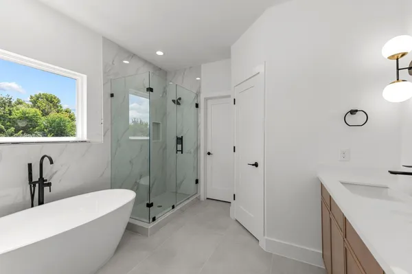 a bathroom with a tub sink and mirror