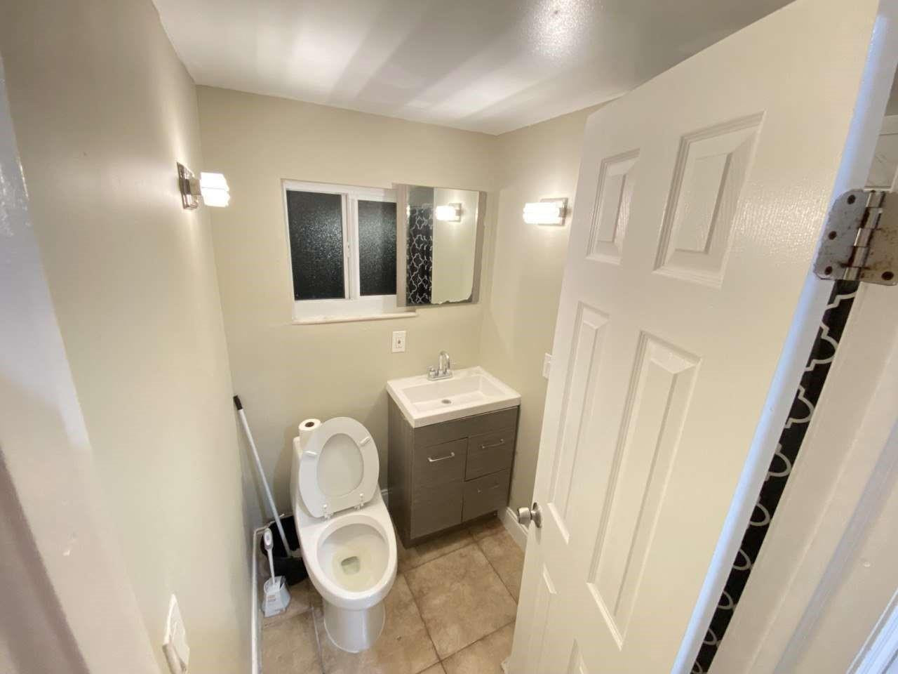141 Northwest 10th Street Pompano Beach, FL 33060 - Photo 12 of 24 a bathroom with a toilet mirror and vanity