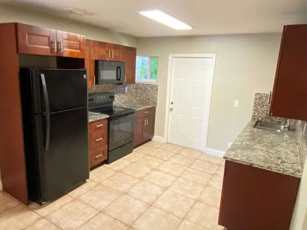 a kitchen with stainless steel appliances granite countertop a refrigerator and a sink