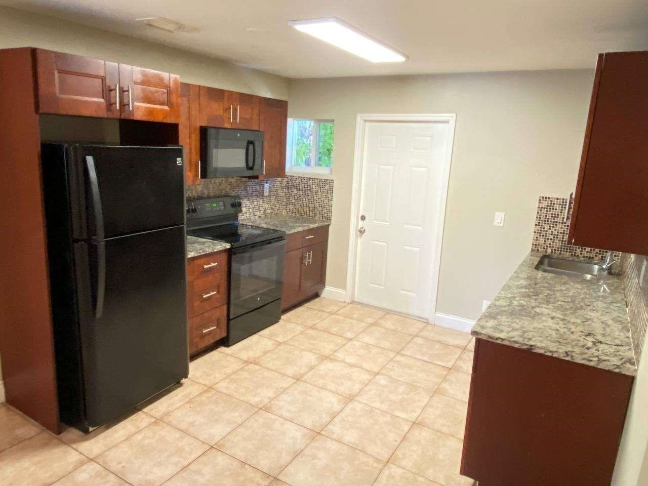 141 Northwest 10th Street Pompano Beach, FL 33060 - Photo 14 of 24 a kitchen with stainless steel appliances granite countertop a refrigerator and a sink
