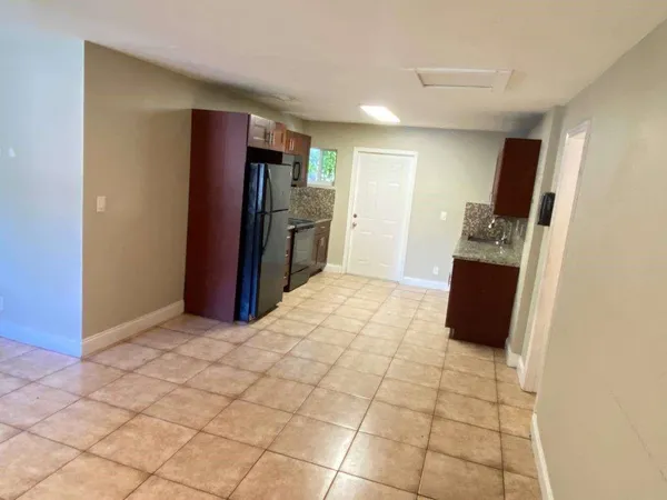 a view of kitchen with furniture and refrigerator