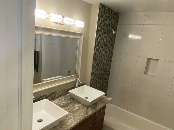 a bathroom with a tub a sink and a shower