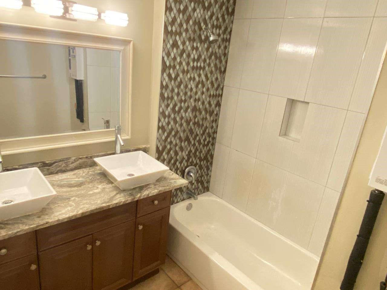 141 Northwest 10th Street Pompano Beach, FL 33060 - Photo 18 of 24 a bathroom with a granite countertop sink and a bathtub