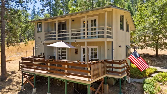 a view of a patio with table and chairs with wooden floor and fence