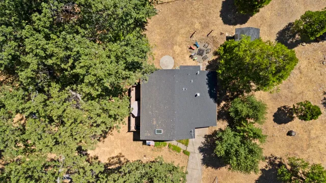 an aerial view of a house with a yard and large trees