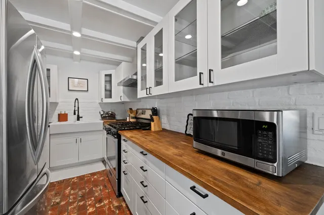 a kitchen with stainless steel appliances a stove microwave and cabinets