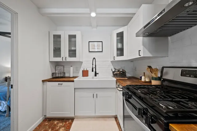 a kitchen with stainless steel appliances a stove a sink and cabinets