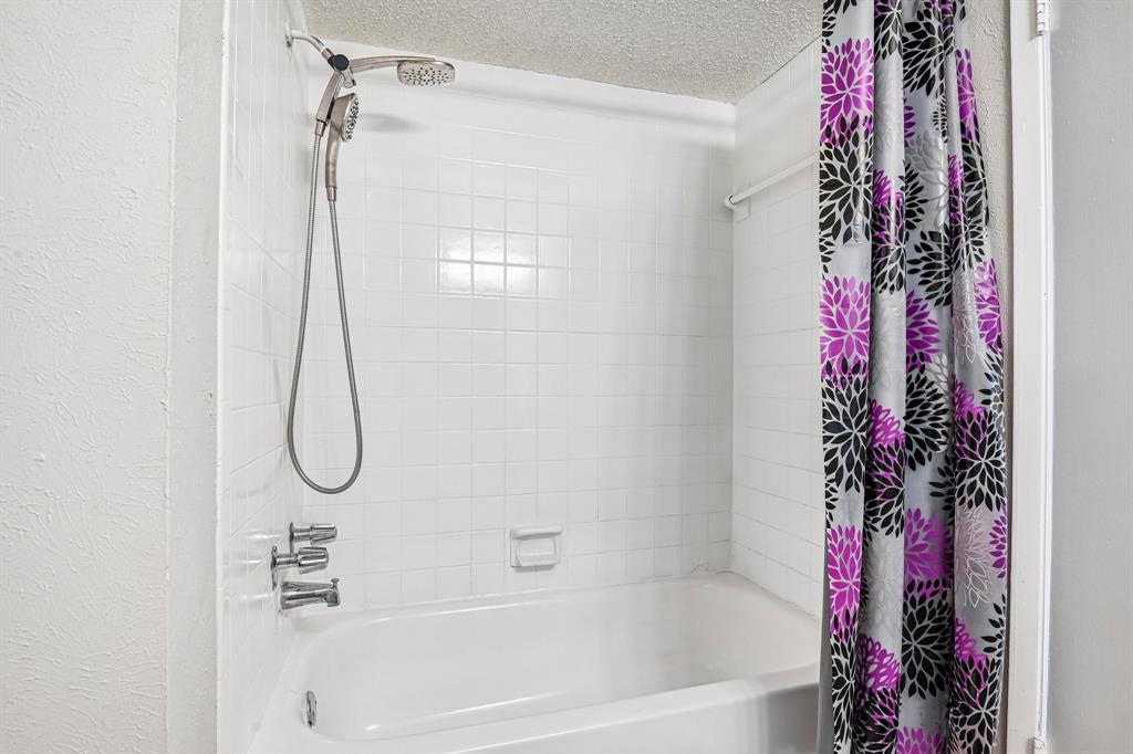 5534 Boca Raton Boulevard, Unit 292 Fort Worth, TX 76112 - Photo 27 of 31 a bathroom with a shower curtain and a shower