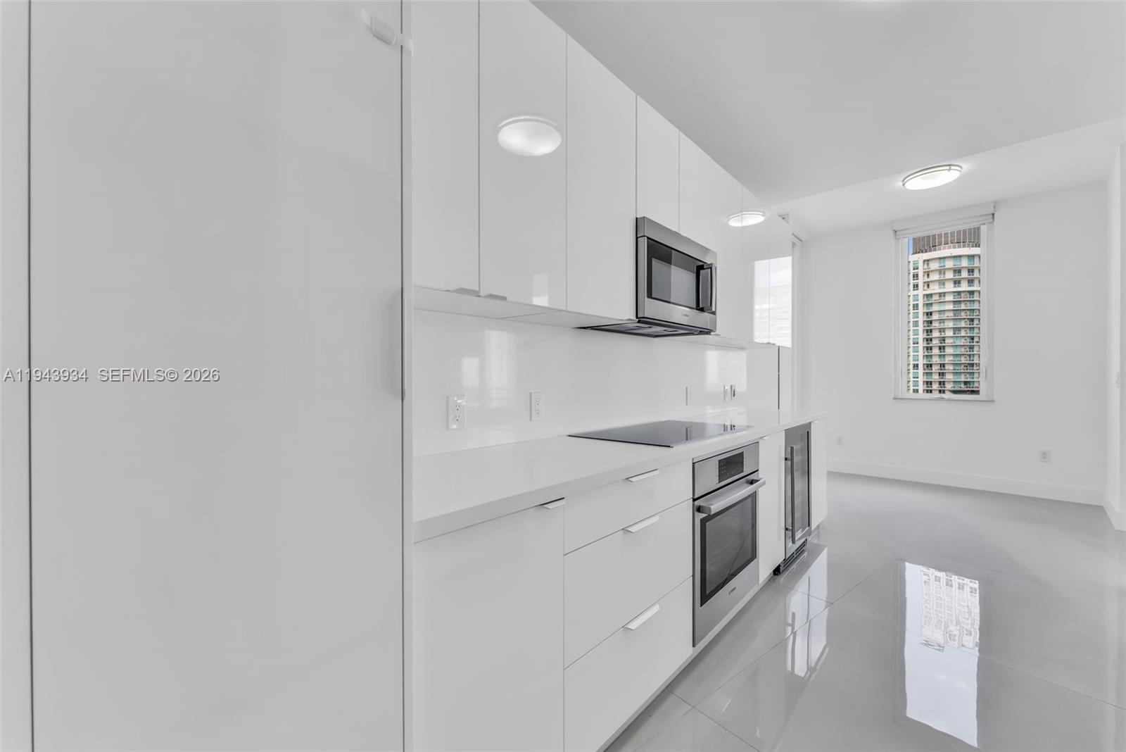 901 Brickell Key Boulevard, Unit 3206 Miami, FL 33131 - Photo 12 of 41 a kitchen with stainless steel appliances granite countertop white cabinets and window