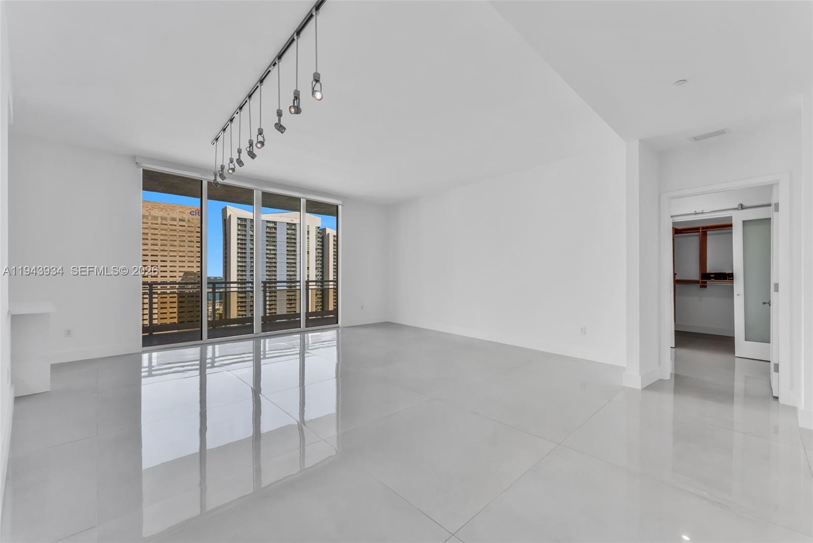 901 Brickell Key Boulevard, Unit 3206 Miami, FL 33131 - Photo 7 of 41 an empty room with windows