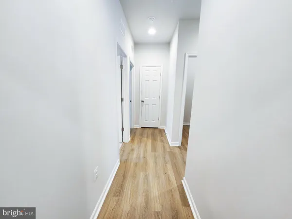 a view of a hallway with wooden floor