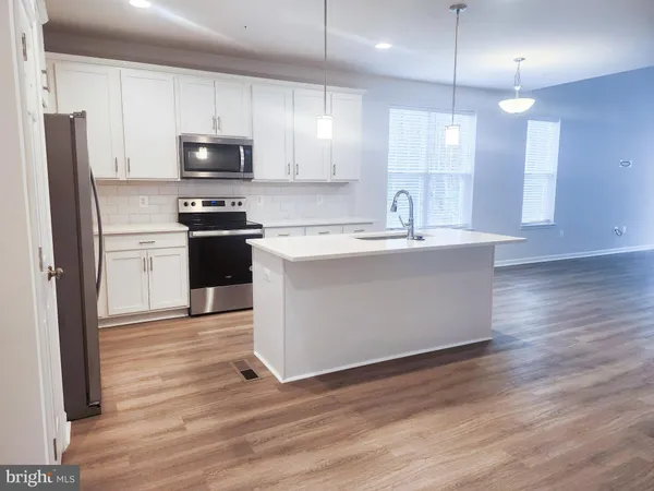a kitchen with stainless steel appliances kitchen island granite countertop a stove a refrigerator a sink and a microwave