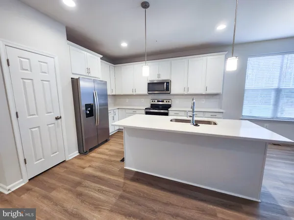 a kitchen with stainless steel appliances a refrigerator sink and microwave