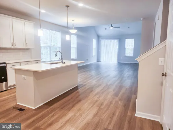 a kitchen with kitchen island a sink and a stove top oven