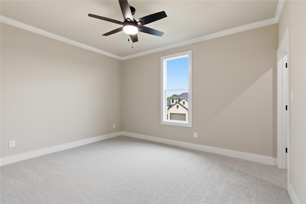 702 Anne Road Van Alstyne, TX 75495 - Photo 20 of 27 Carpeted interior room featuring neutral wall tones, white trim, and a ceiling fan with integrated lighting