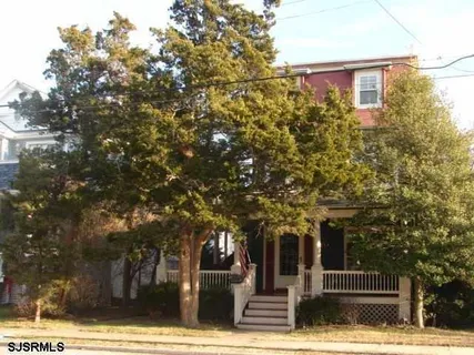 a front view of a building with trees
