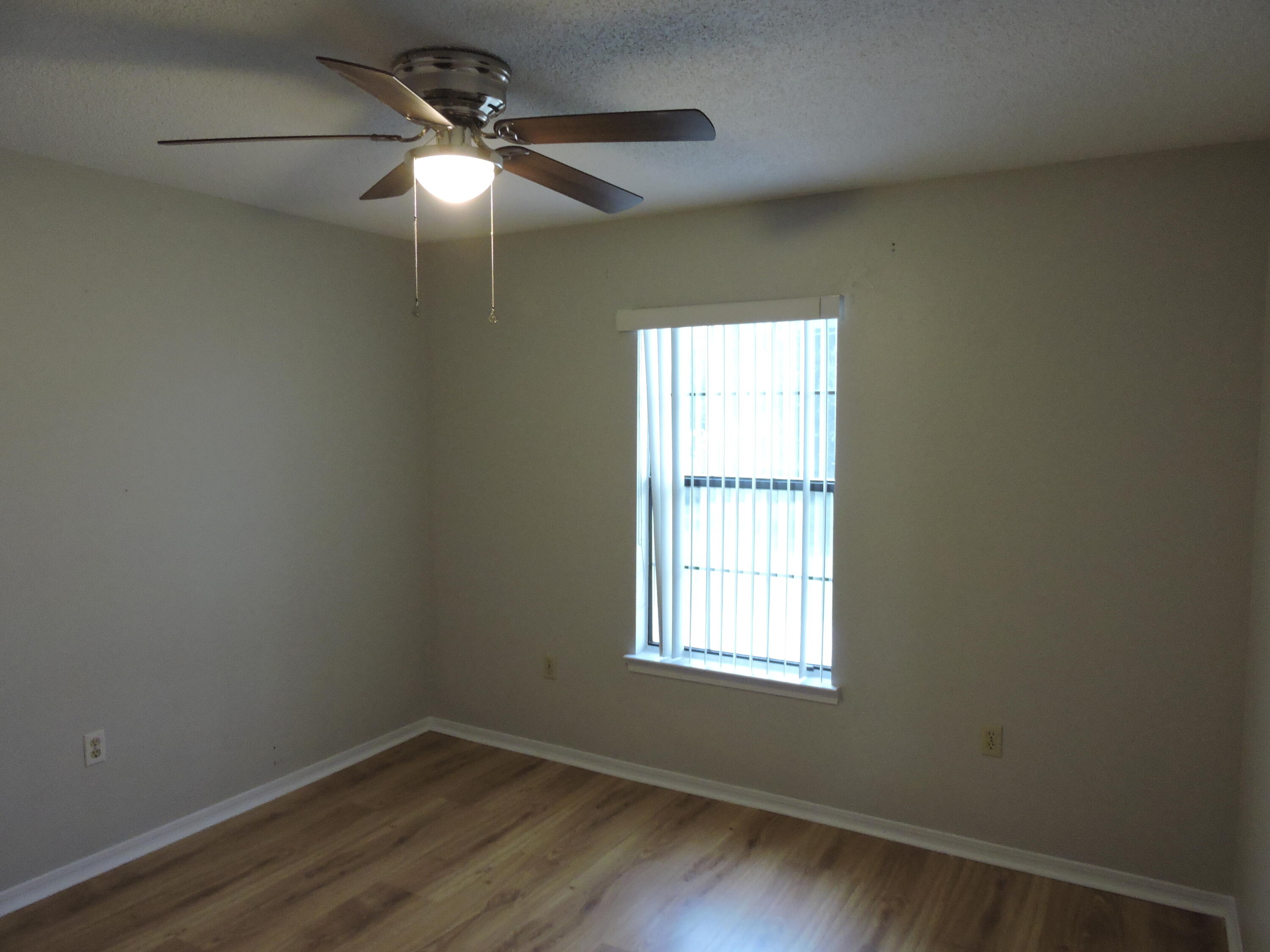 813 Valley Road Crestview, FL 32539 - Photo 15 of 18 an empty room with wooden floor and windows