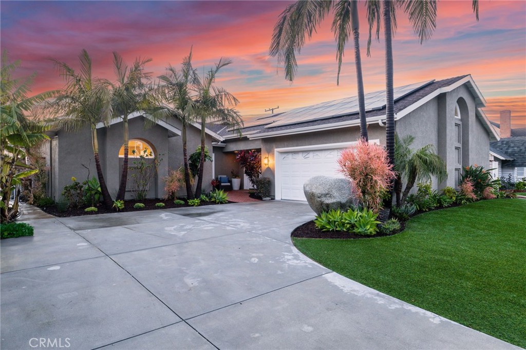 a front view of a house with a garden and trees