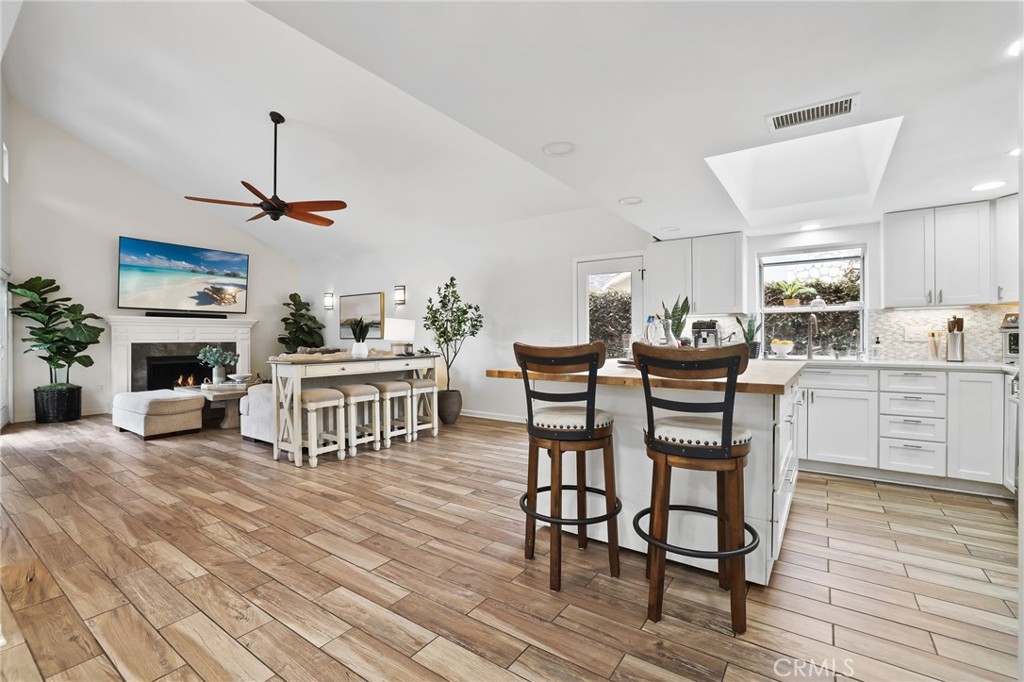 11731 Wembley Road Rossmoor, CA 90720 - Photo 11 of 51 a living room with furniture a fireplace and kitchen view