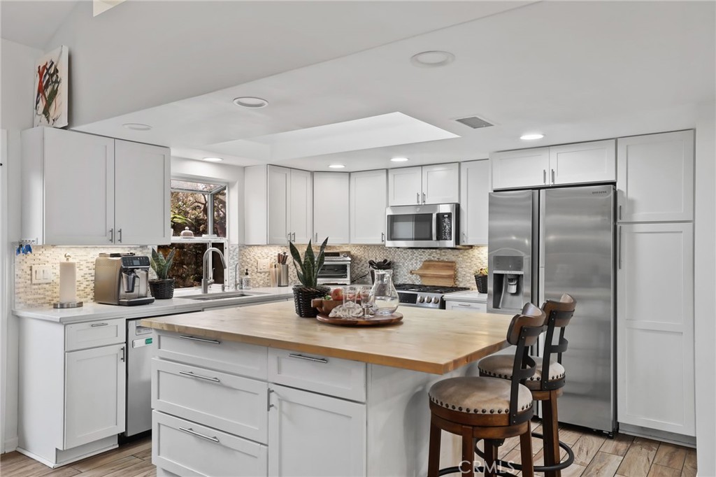 11731 Wembley Road Rossmoor, CA 90720 - Photo 14 of 51 a kitchen with sink a counter and chairs