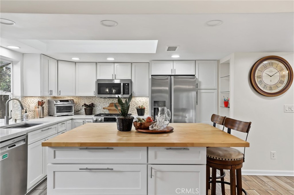 11731 Wembley Road Rossmoor, CA 90720 - Photo 16 of 51 a kitchen with a table chairs and refrigerator