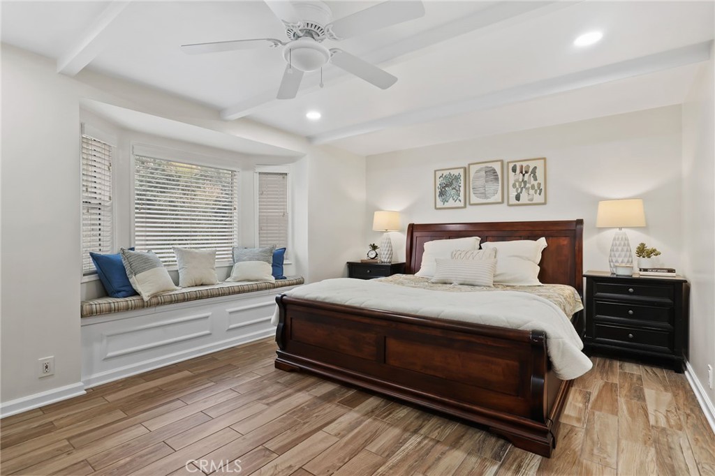 11731 Wembley Road Rossmoor, CA 90720 - Photo 23 of 51 a bedroom with a bed and wooden floor