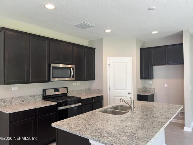a kitchen with a sink a microwave a stove and refrigerator