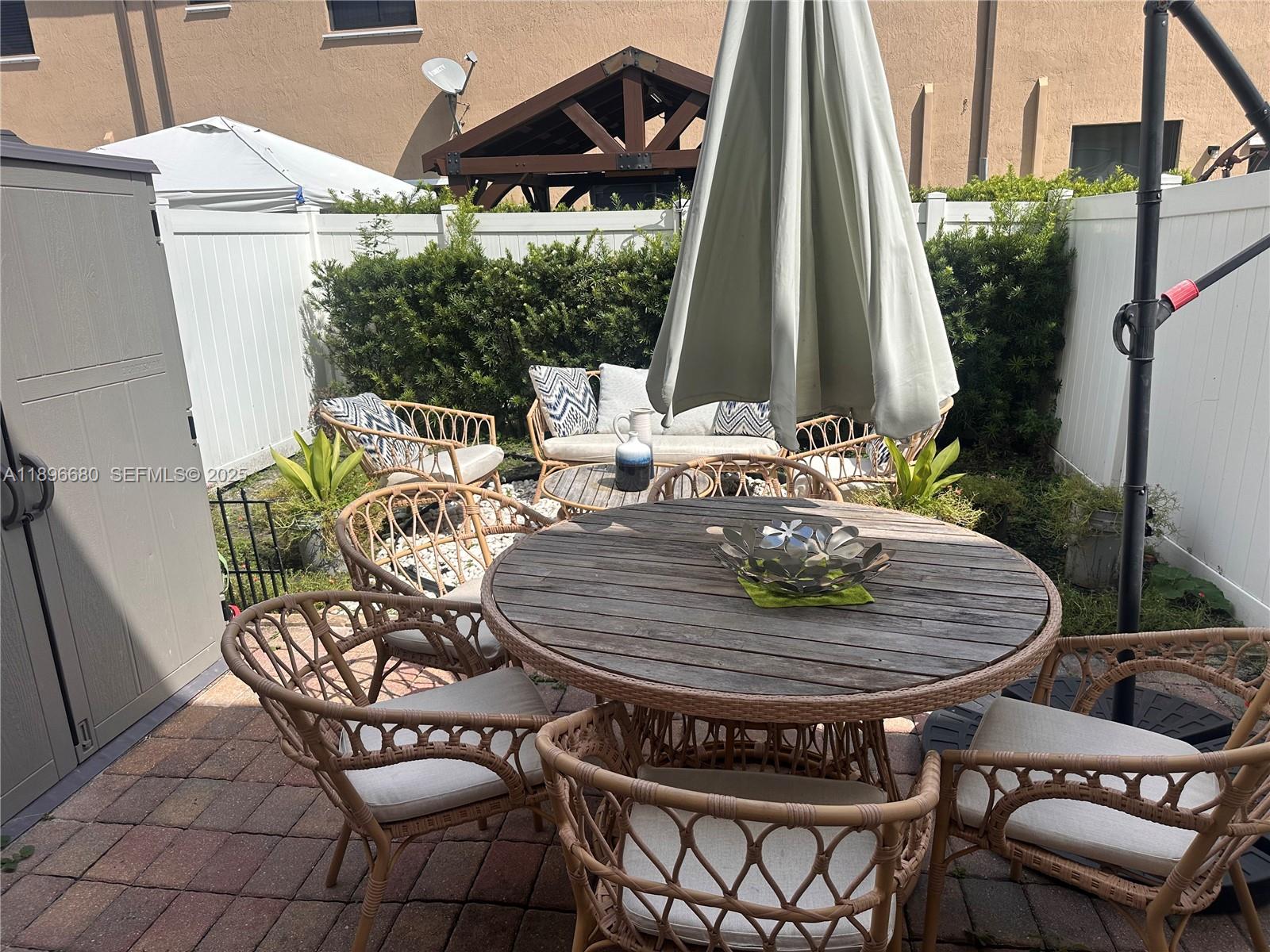 8867 West 35th Way Hialeah, FL 33018 - Photo 3 of 15 a table and chairs sitting in front of a house