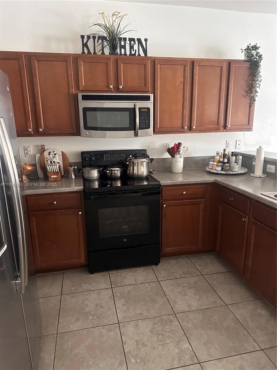 8867 West 35th Way Hialeah, FL 33018 - Photo 7 of 15 a kitchen with a stove sink and cabinets