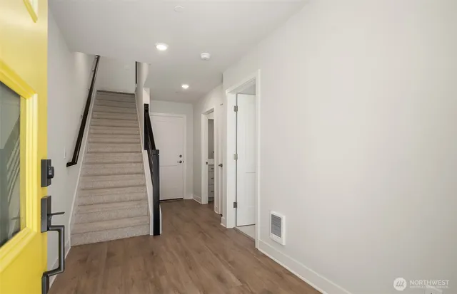 a view of a hallway with wooden floor and staircase