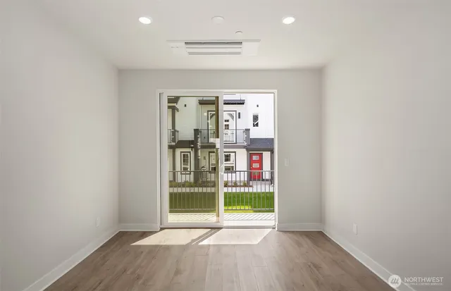 an empty room with wooden floor and door