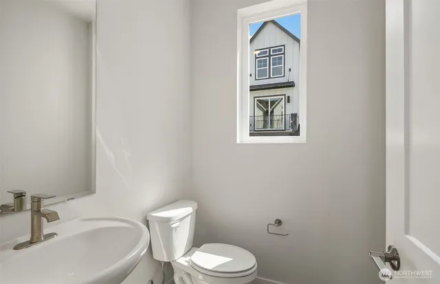 a bathroom with a toilet a sink and mirror