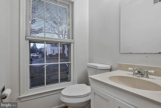 a view of an empty room with wooden floor and a ceiling fan
