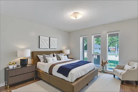 a bedroom with bed and a large window