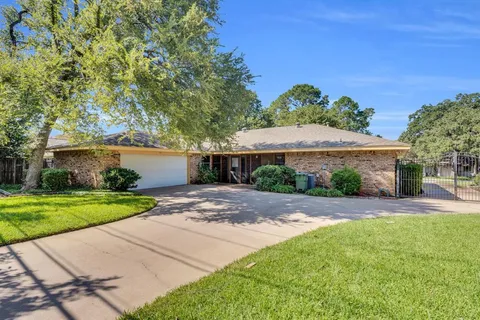 a front view of a house with a yard and potted plants